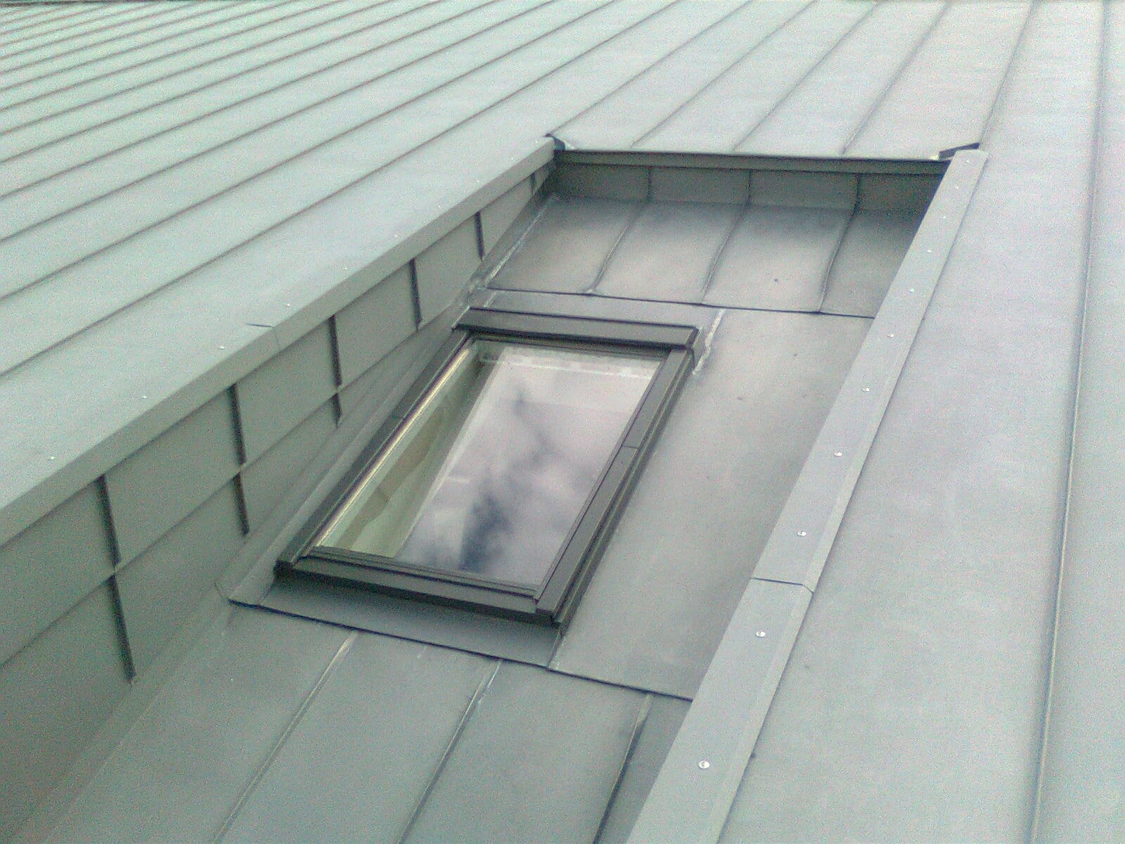 Dachfenster mit sauber eingefasstem Stehfalz-Metalldach